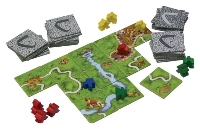 A Carcassonne map of roads and cities being built from square tiles, with meeples in play.