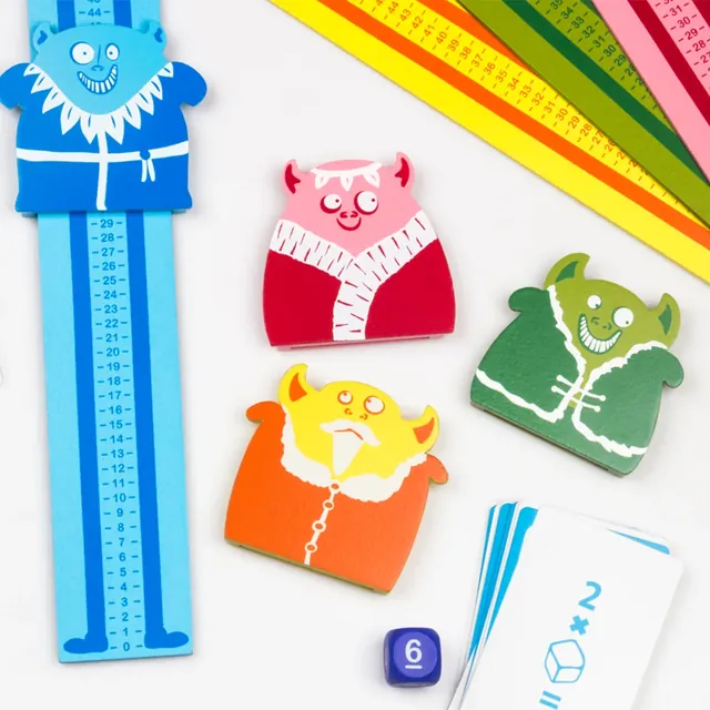 The monster sliders lying beside the rulers, with a die and a stack of puzzle cards