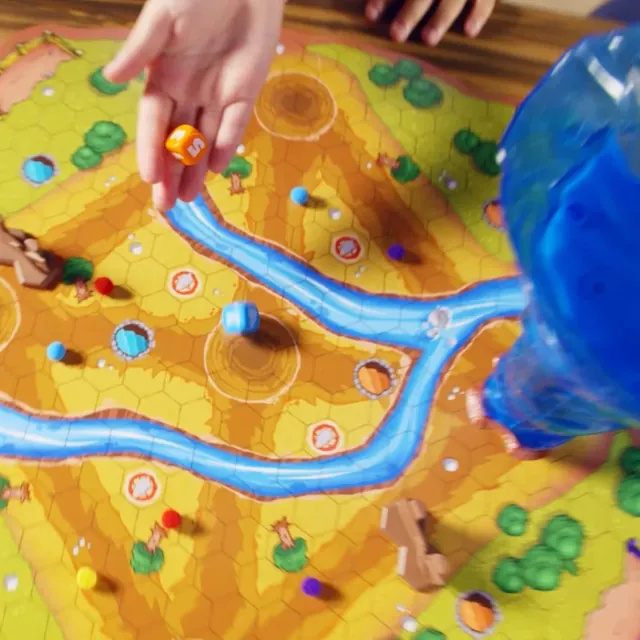A hand moving a sheep along the river path on the board