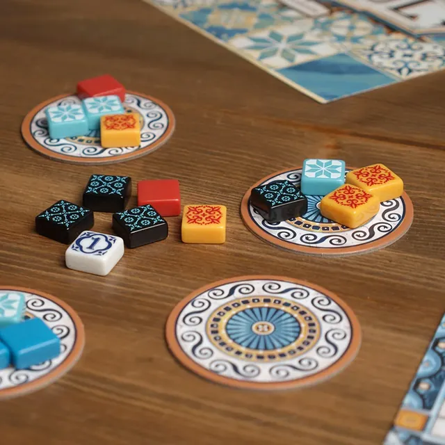 Factory displays on a wooden table during a game, with some tiles already taken