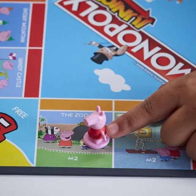 A hand moving the Peppa token along the board past the zoo