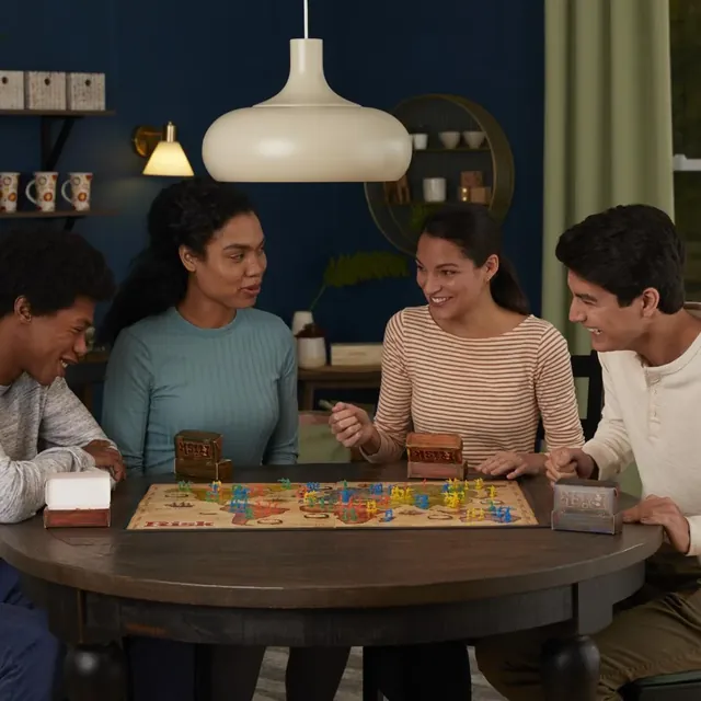 Four young adults playing Risk round a table at home