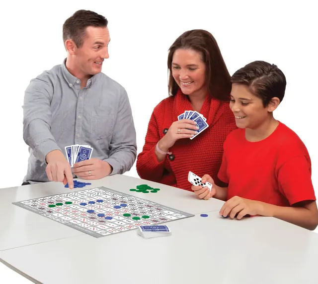 A father, mother and son playing Sequence, holding cards over the board