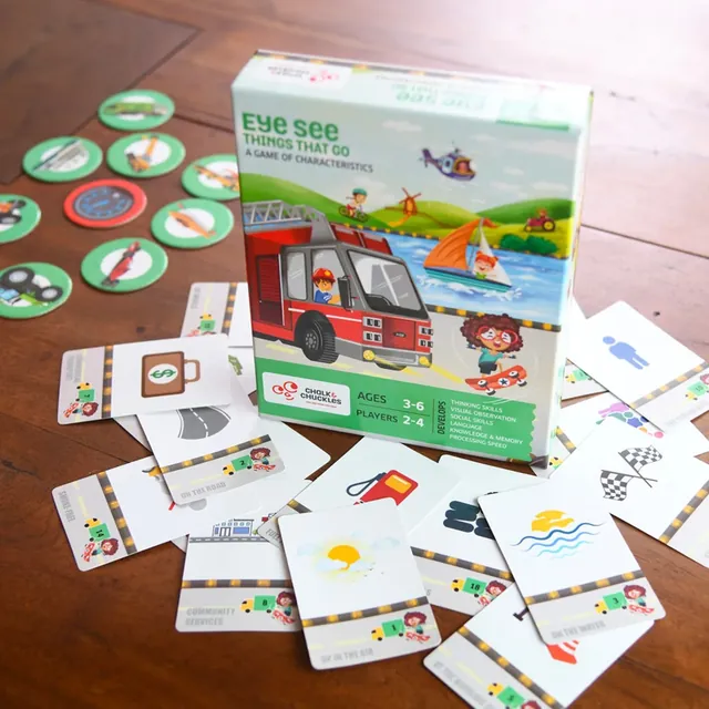 The box standing among vehicle tokens and characteristic cards, such as a fuel pump and a chequered flag