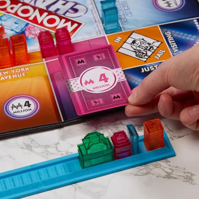 A hand placing a 4 million cash card on a property on the board
