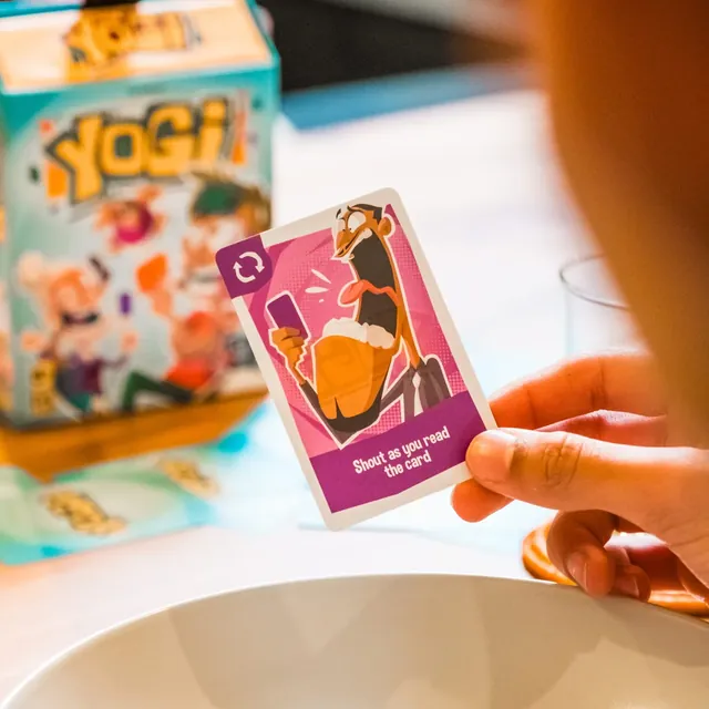 A hand holding a card that says 'Shout as you read the card'