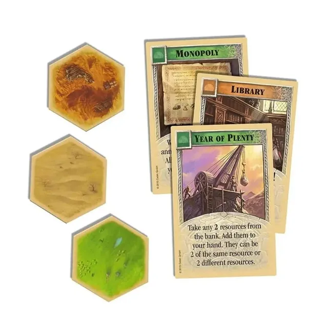 Three terrain hexes (hills, desert, pasture) next to three development cards: Monopoly, Library and Year of Plenty