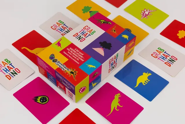 The box lying on a spread of dinosaur cards