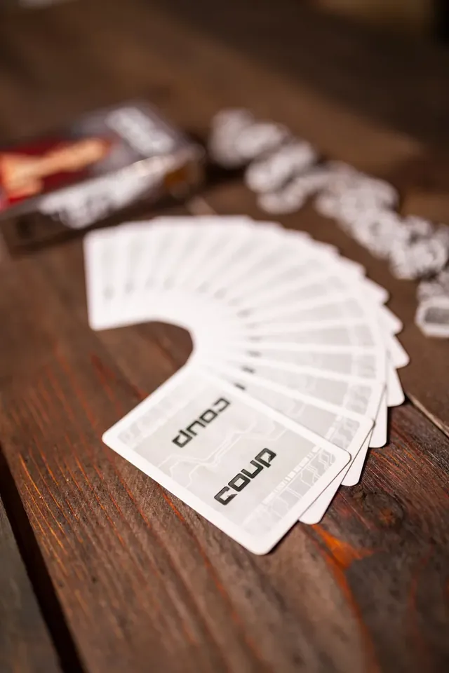 A hand of Coup cards fanned out face down