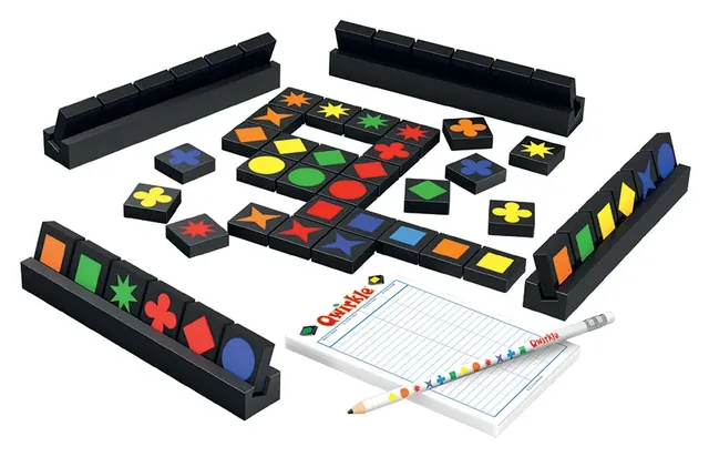 Qwirkle tiles in a grid with four black wooden tile racks, a score pad and a pencil