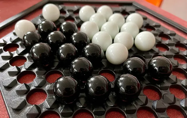 Black and white Abalone marbles close together on the board