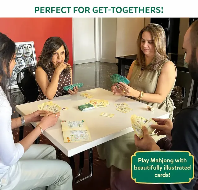 Four adults playing Mahjong Go! at a white table, holding fans of cards