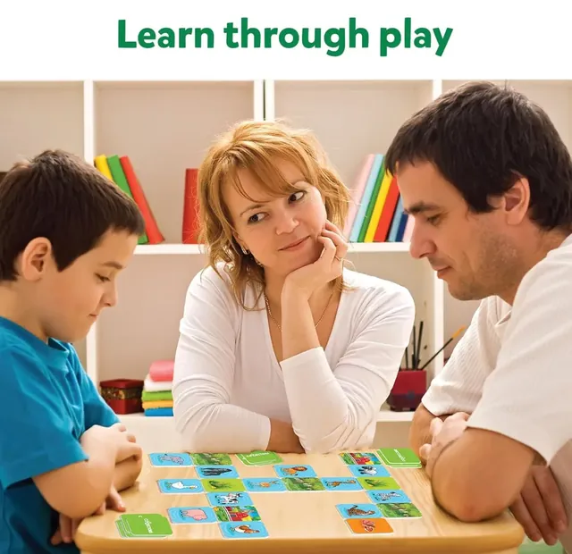 A boy and his parents laying picture tiles on a table