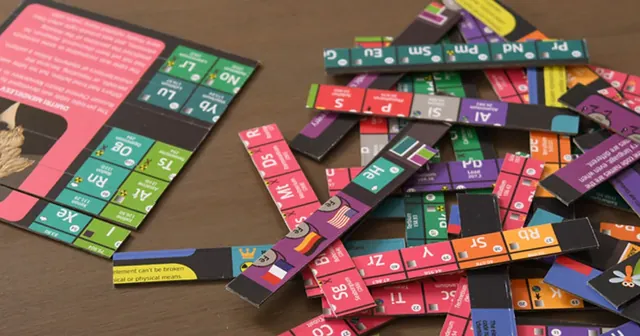 Coloured element sticks scattered on a table, showing symbols such as Sr, Xe and Pm
