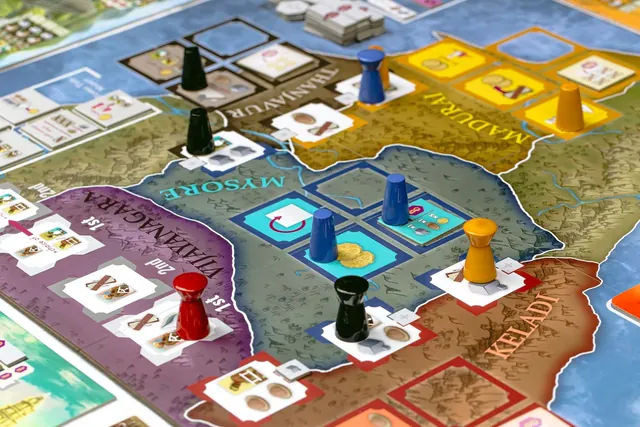 Wooden pawns in four colours on the kingdoms of Mysore and Madurai on the map