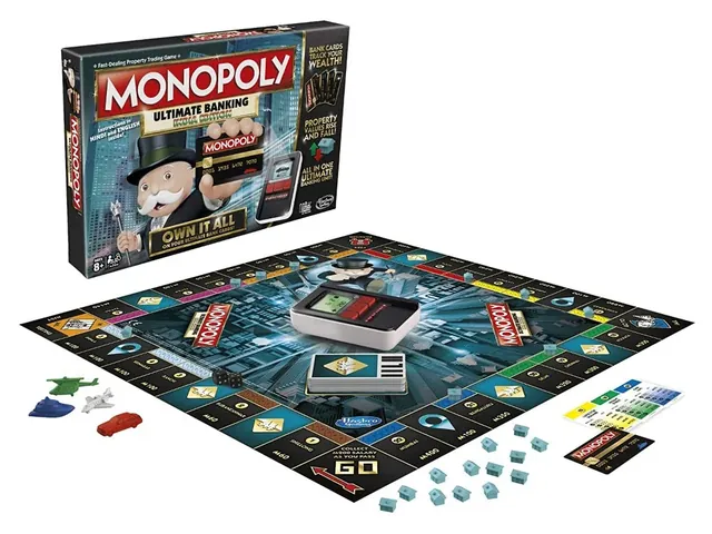 The box behind the laid-out board, with the Ultimate Banking unit, tokens, houses and cards