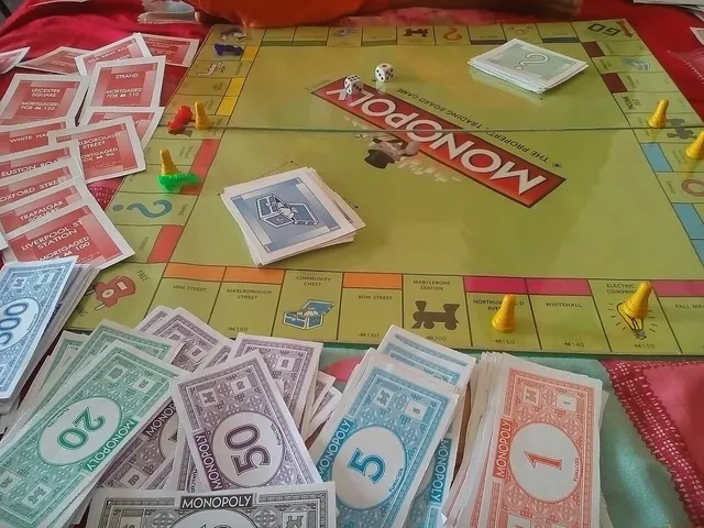 A game of Monopoly in progress, with money, cards and tokens on the board (another edition)