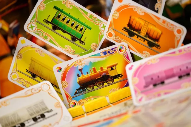 Train cards showing carriages in green, orange, yellow and pink, and a rainbow locomotive
