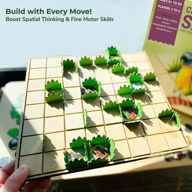 A hand holding the grid with grass hedges standing on it and animal tokens in claimed squares
