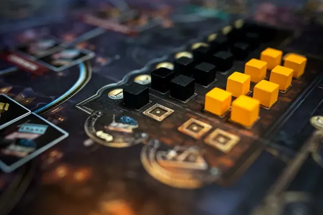 Black coal cubes and orange iron cubes in the market tracks on the board