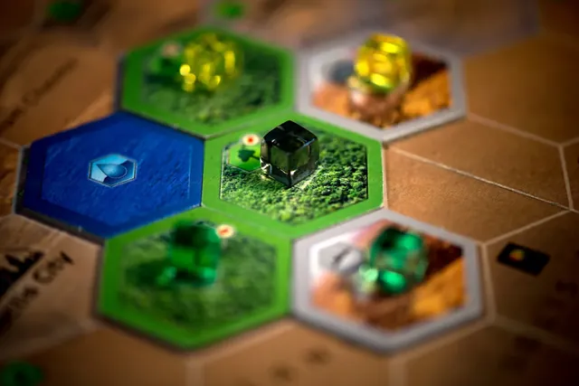 Green greenery and blue ocean tiles on the board with coloured player cubes