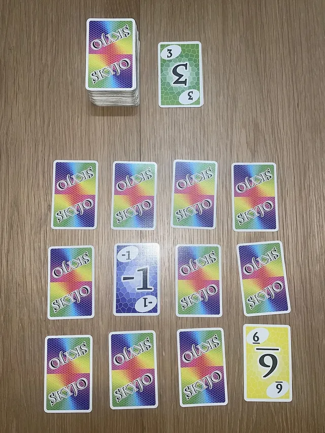 A player's grid of twelve SKYJO cards, three rows of four, a few turned face up