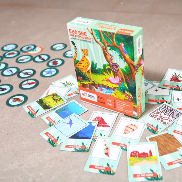 The box with animal tokens and characteristic cards spread out on a table
