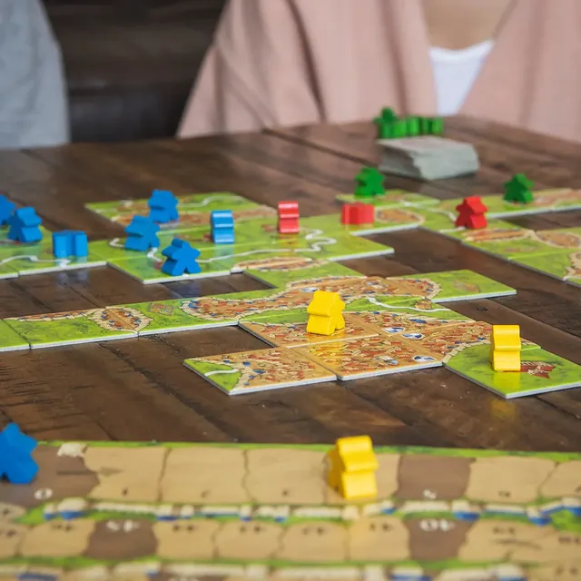 Close-up of a big map in progress with coloured meeples on cities and roads