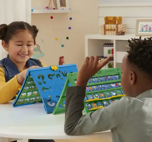 Two children playing Guess Who? Animal Friends at a white table