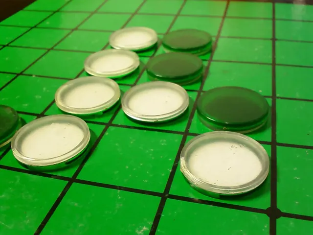 Black and white Othello discs on a green board