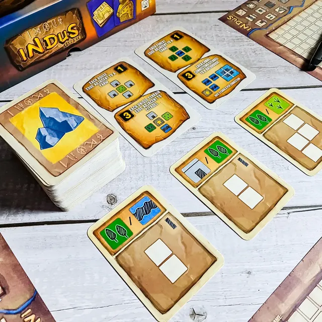 Terrain cards showing house, farm and water shapes beside the deck and a map sheet