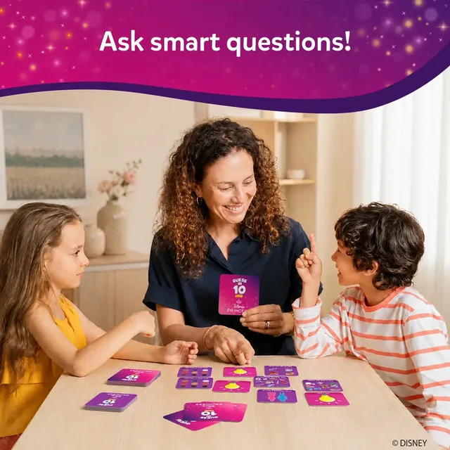 A mother and two children playing at a table with pink game cards and tiles