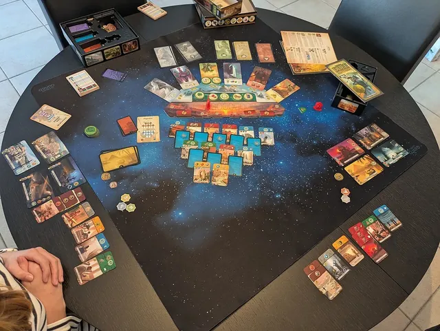 A game of 7 Wonders Duel with the Pantheon expansion laid out on a dark round table