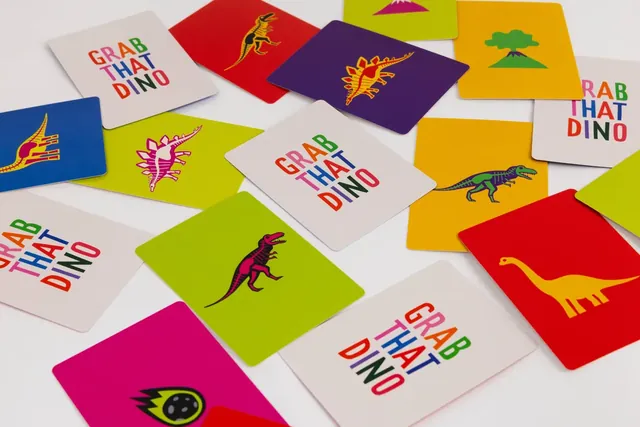 Scattered cards with dinosaurs in bright colours and a comet card