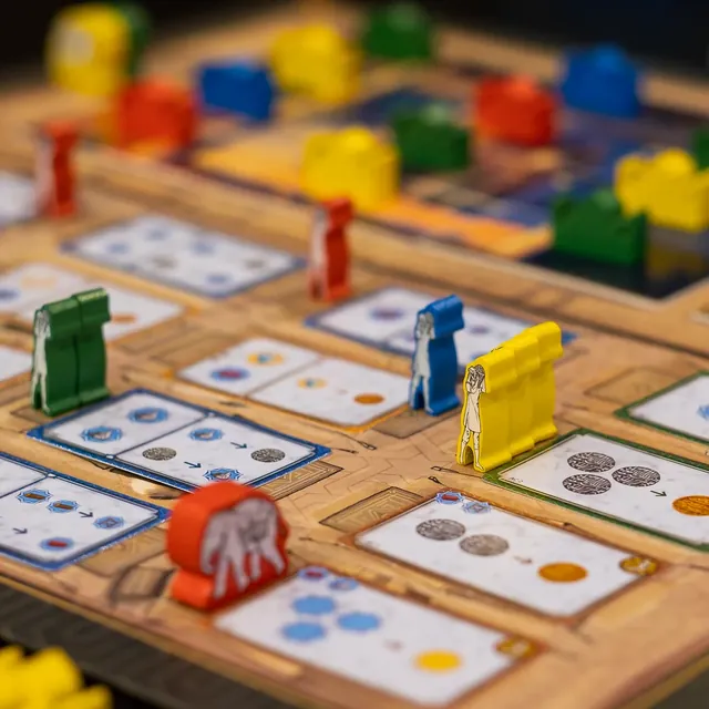 Coloured worker meeples and an elephant on the bazaar cards