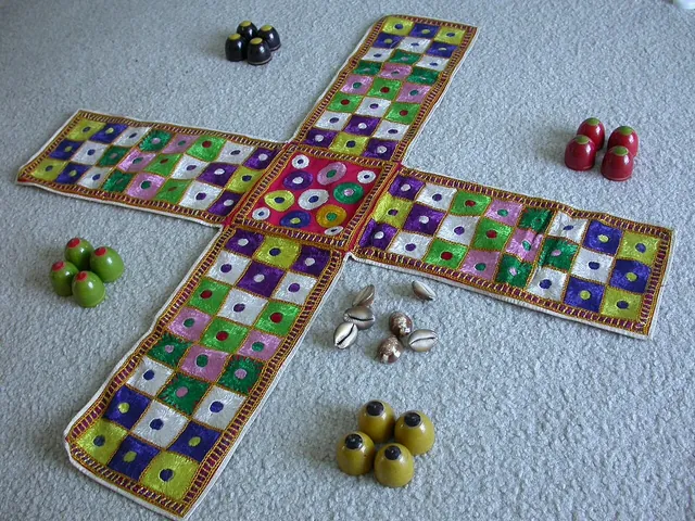 A cross-shaped cloth chaupar board with wooden pieces in four colours