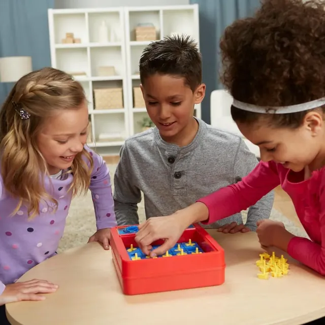 Three children playing the classic Perfection at a table