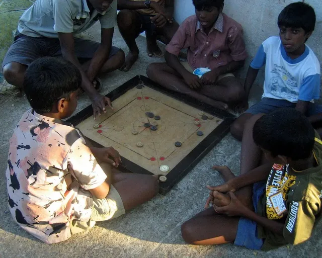 Children playing carrom on the floor in Mamallapuram, Tamil Nadu