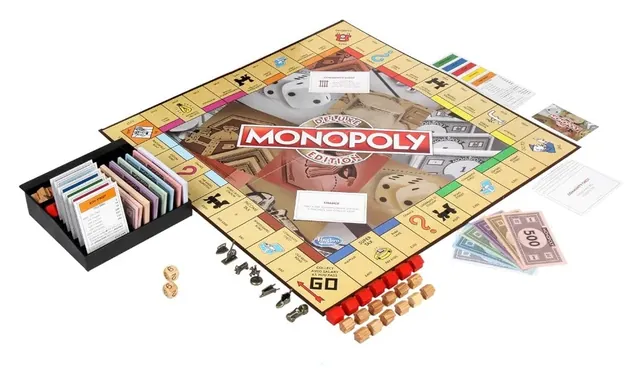 The Deluxe board laid out with the banker's tray, tokens, wooden houses and hotels, money and cards