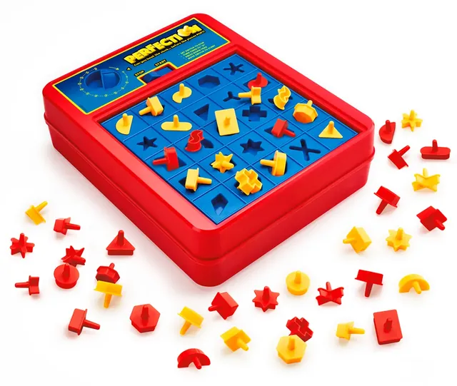 The red game unit with yellow shapes in the tray and red and yellow shapes around it