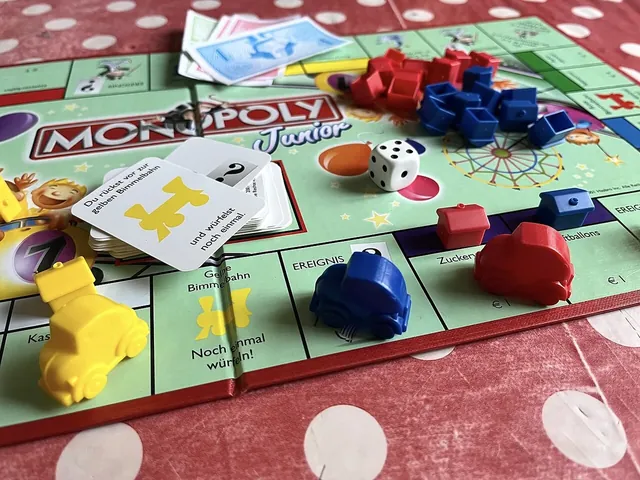 A German Monopoly Junior game in progress: car tokens, coloured markers and a die on the board